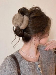 Détail d'une pince à cheveux en peluche kaki doux pour coiffure chignon d'automne