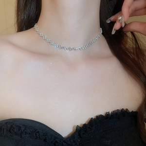 Close-up of minimalist silver tassel choker with zircon on female model neck