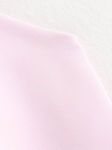 Close-up of pink woven fabric texture showing detailed crisscross pattern and material thickness