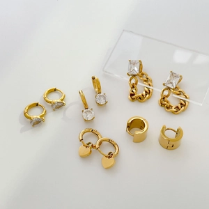 Selection of gold earrings featuring pear-cut cubic zirconia and chain link heart designs
