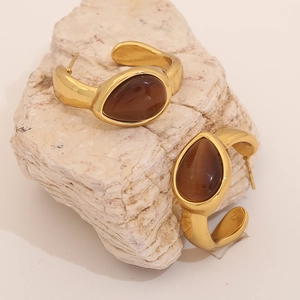 Elegant gold C-shaped earrings with brown teardrop cat-eye stone on textured stone