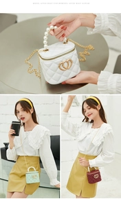 Detailed view of mini quilted jelly bag with pearl handle and golden chain strap