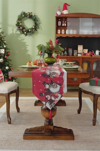 Close-up of red Christmas table runner with cartoon penguins and decorative red tassels