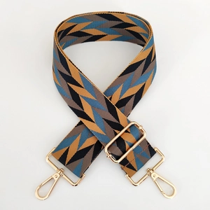 Close-up of adjustable woven colorful geometric purse strap with gold metal hardware