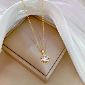 Close-up of gold titanium necklace with hollow zircon pendant on silk and beige jewelry box