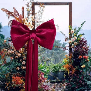 Detailed view of a large burgundy velvet bow for wedding and holiday venue decoration