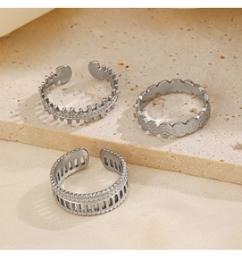 Detailed view of silver stainless steel rings with geometric textures on stone background