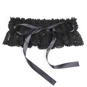 Detail of elegant black elastic lace waist belt with large decorative satin ribbon bow