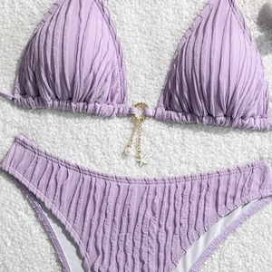 Detail of lavender bikini top with textured fabric, golden ring, pearl and starfish charms