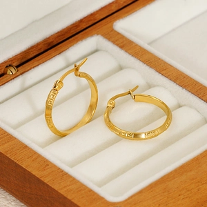 Créoles minimalistes en acier titane plaqué or 18K avec motif grec sur boîte à bijoux