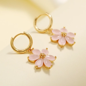 Macro shot of pink six-petal flower charms with gold rims and translucent petals