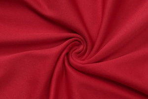 Gros plan sur un tricot rouge élastique à texture en spirale montrant douceur et drapé