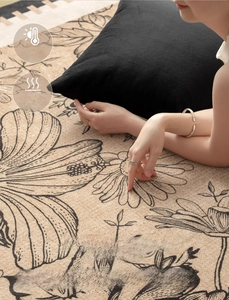 Detail of vintage French style beige carpet showing soft texture and black floral patterns