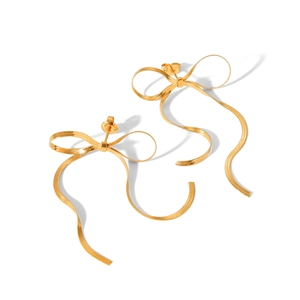 Close-up of gold 18k stainless steel bow earrings with long snake chain tassels