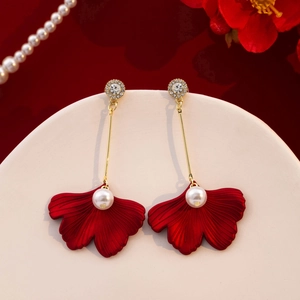 Exquisite red leaf pearl earrings with gold accents and rhinestones on a gift display