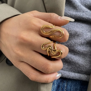 Twisted gold titanium steel rings set for women on model hand in natural lighting