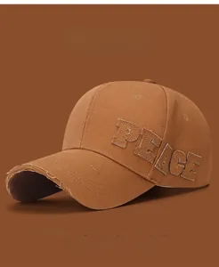 Détail de la casquette vintage avec écusson PEACE brodé et bords de visière effilochés