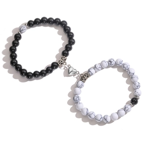Detail of magnetic heart clasp connecting black and marble bead bracelets for couples