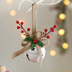 Close-up of white metal Christmas bell ornament with red berries and burlap bow detail