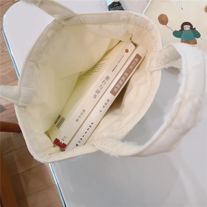 Spacious interior of white quilted fleece tote bag showing large capacity for books