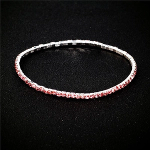 Close-up of a slim silver bracelet featuring a row of square-cut pink crystals