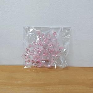 Pink acrylic crystal snowflake ornaments and hanging ropes in clear plastic packaging