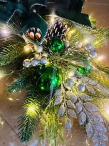 Close-up of Christmas stair garland with pine cones, silver baubles and LED lights