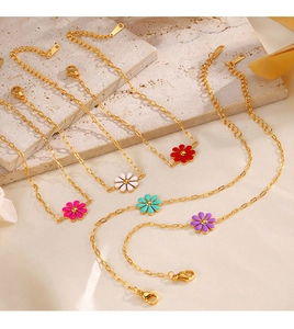 Detailed set of five gold daisy bracelets with colorful enamel floral charms in warm lighting