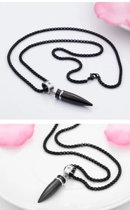 Close-up of a black bullet-shaped pendant featuring a silver ring set with white zircons