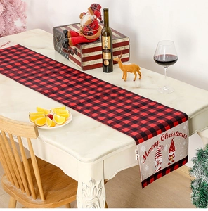 Detail of red and black buffalo plaid Christmas table runner with festive gnome print