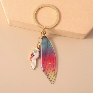 Close-up of bird and gradient butterfly wing keychain with gold metal ring detail