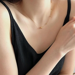 Close-up of a delicate 925 silver beaded chain necklace worn on the collarbone