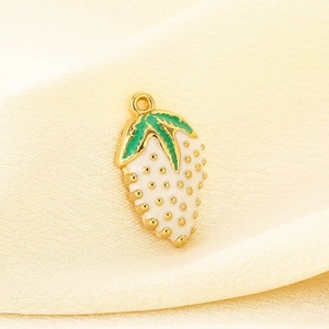 Macro shot of 3D white strawberry pendant with gold plating and green leaf detail