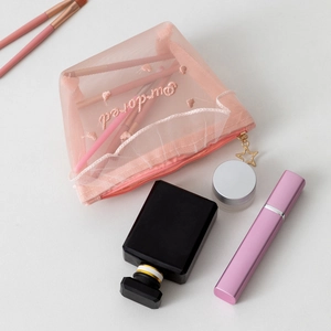 Detail of pink mesh makeup bag featuring embroidered Bonjour text and star zipper pull