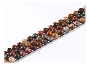 Macro shot of colorful natural Picasso stone round beads with polished earth tone textures