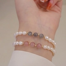 Detail of natural freshwater pearl bracelet with pink and grey gemstones and gold beads