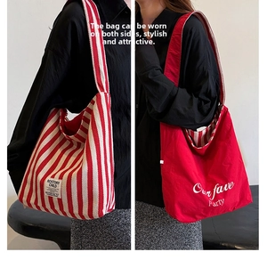 Close-up of a double-sided canvas tote bag showing striped and solid red designs