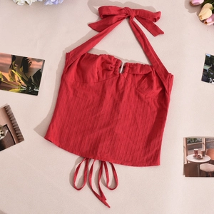 Dettaglio top halter rosso in maglia a coste con fiocco al collo e lacci regolabili