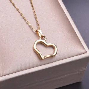 Detail of a minimalist gold hollow heart pendant necklace on a luxury jewelry box
