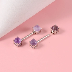 Macro detail of stainless steel nipple ring with purple opal screw beads on pink background