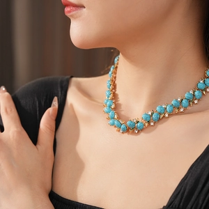 Détail d'un collier vintage en turquoise bleue avec petits diamants et base dorée