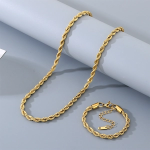 Détail macro d'un ensemble collier et bracelet en maille torsadée dorée avec fermoir