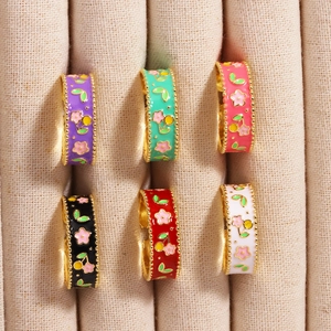 Details von sechs bunten Emaille-Blumenringen in einem beigen Samt-Schmucktablett