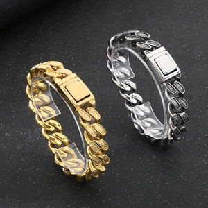 Close-up of heavy cuban link bracelets in gold and silver steel with secure box clasp