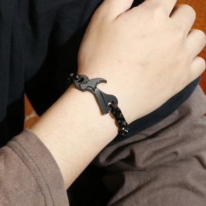 Detailed shot of black beaded men's bracelet with wrench and hammer tool charms