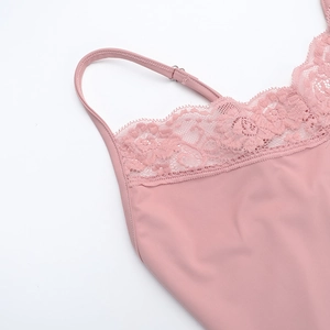 Dettaglio del patchwork in pizzo rosa e del tessuto liscio sull'abito con spacco