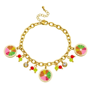 Detail of gold chain bracelet with colorful enamel orange slice and crystal charms