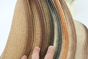 Detail of multi-tone striped straw hat showing fine weave texture and summer sun protection