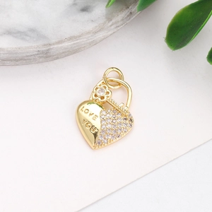 Detail of gold-plated heart key pendant with LOVE YOU engraving and clear gemstones