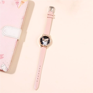 Detail of cute cat shaped pink leather watch with Roman numerals and kitten dial design